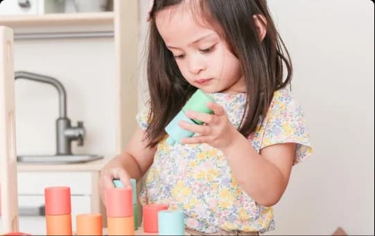 Child with the Wooden Stacking Pegboard from The Adventurer Play Kit