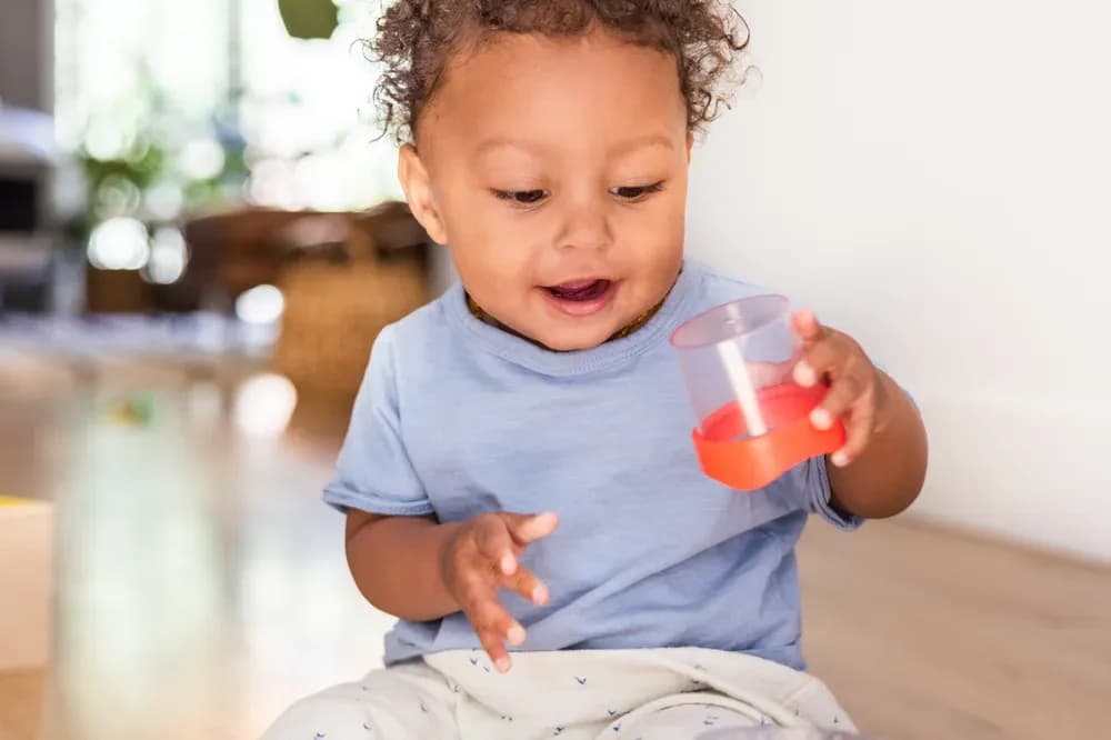 Child playing with the Nesting Stacking Dripdrop Cups from The Inspector Play Kit