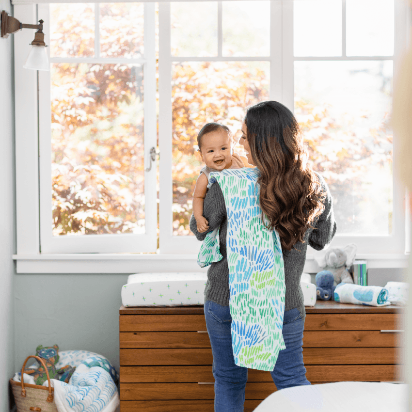 Woman holding a baby with the Lovevery Nursery Bundle